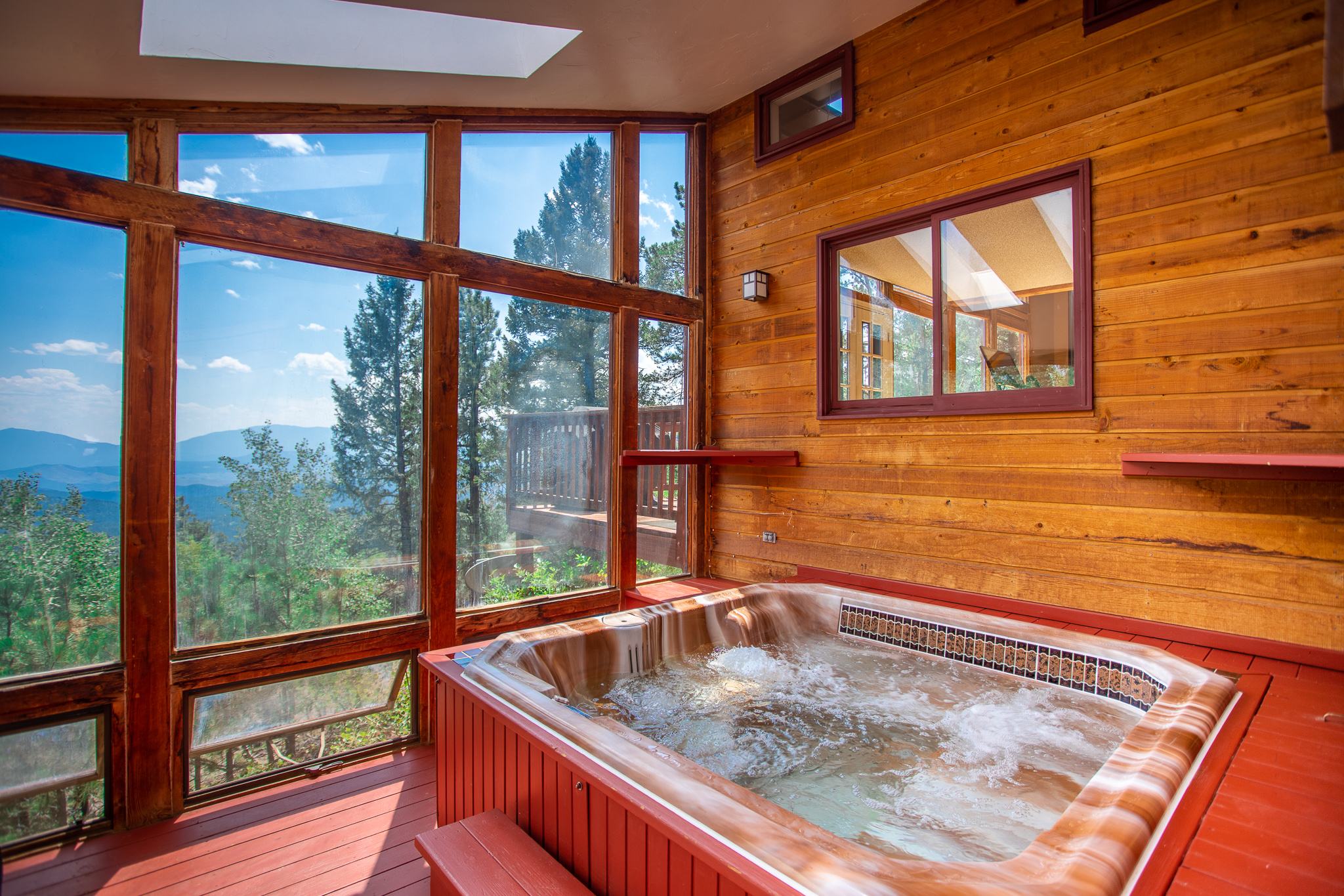Wood-paneled hot tub room with large windows