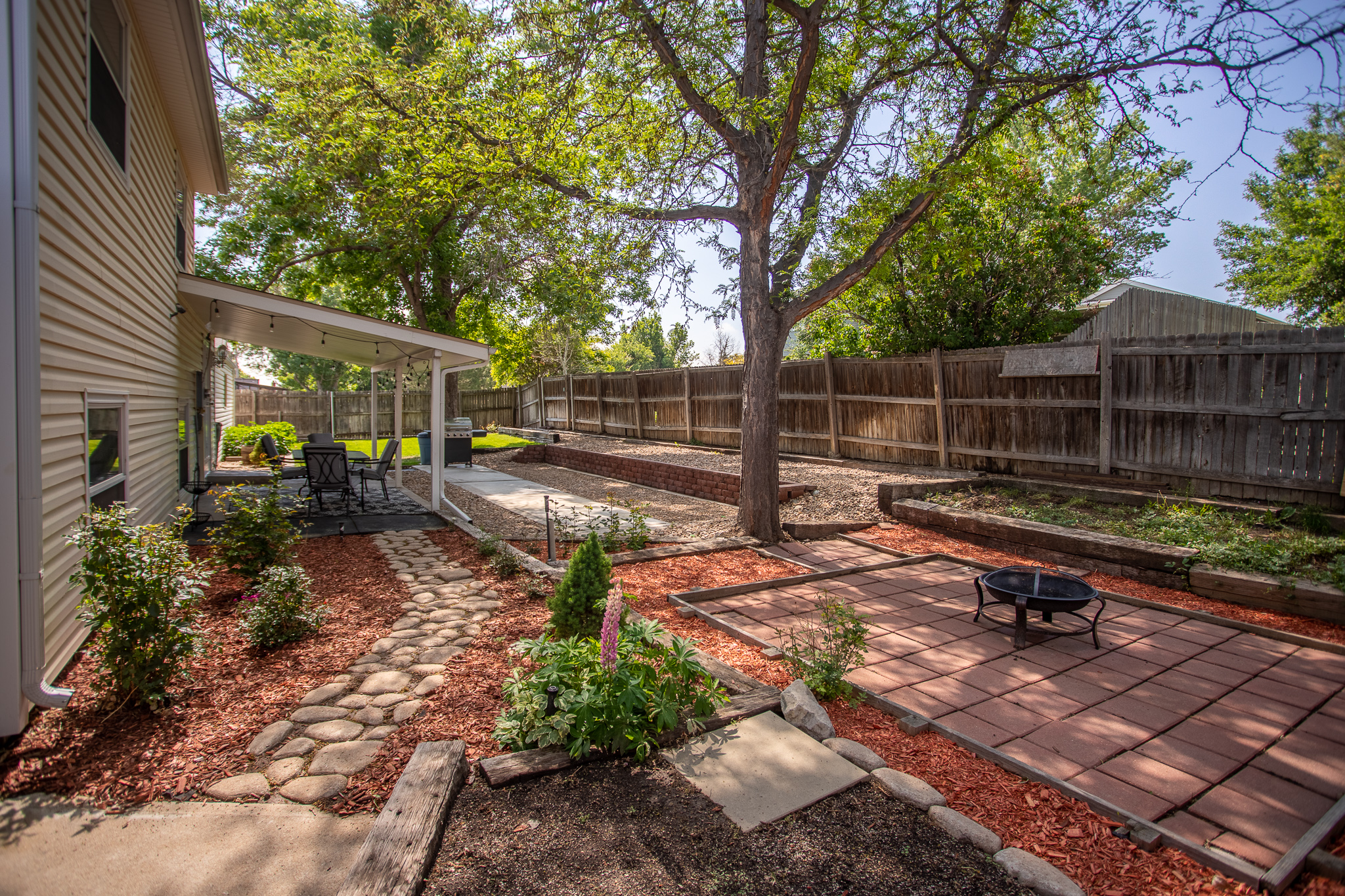 Backyard patio with trees and fire pit